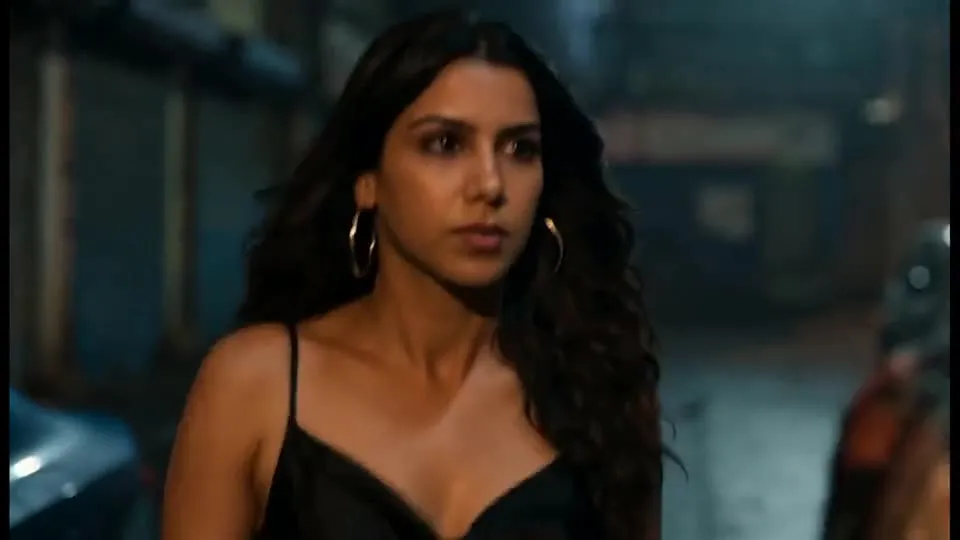 A woman in a black dress in a night-time street