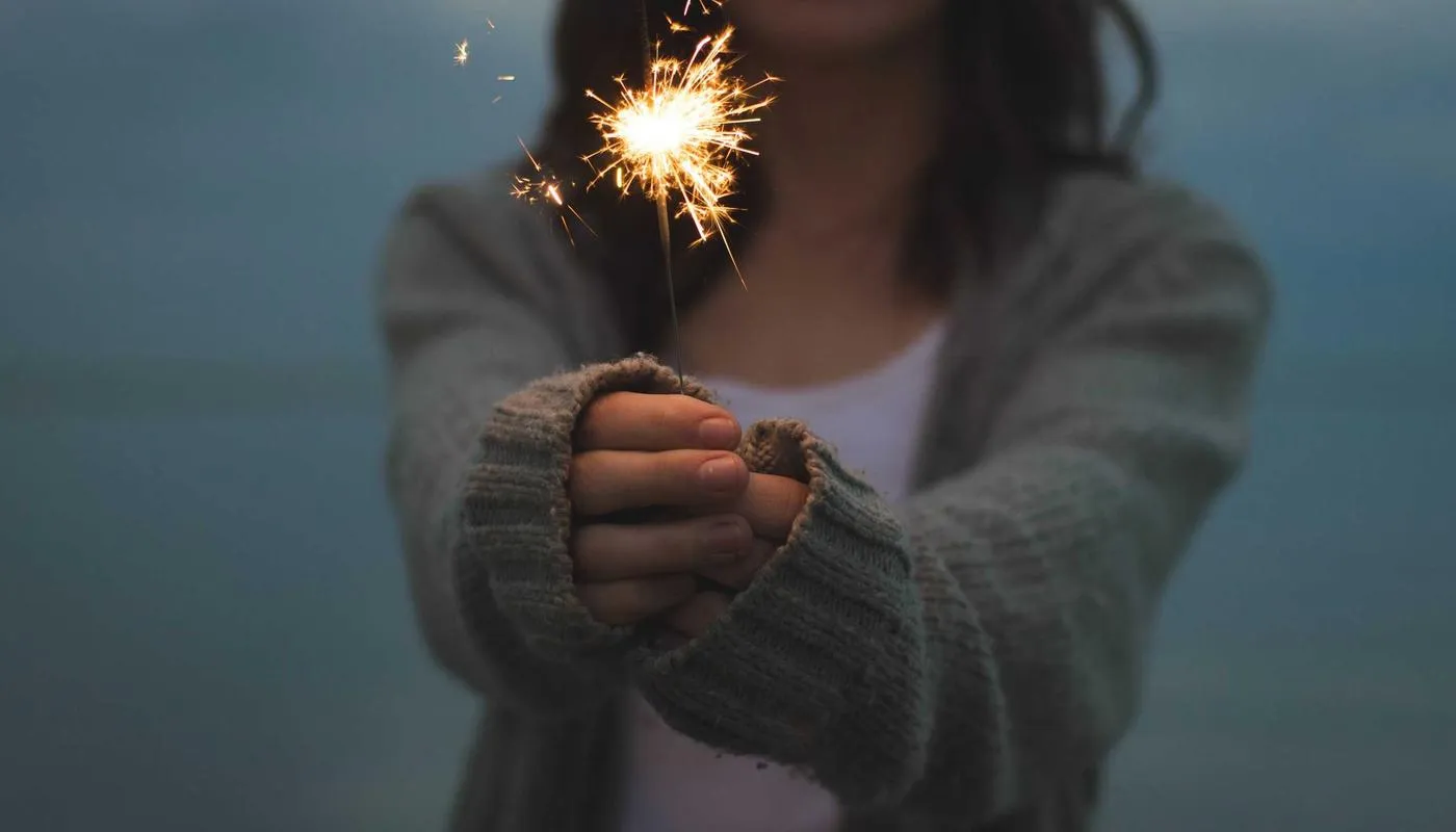 Hands holding a lit sparkler